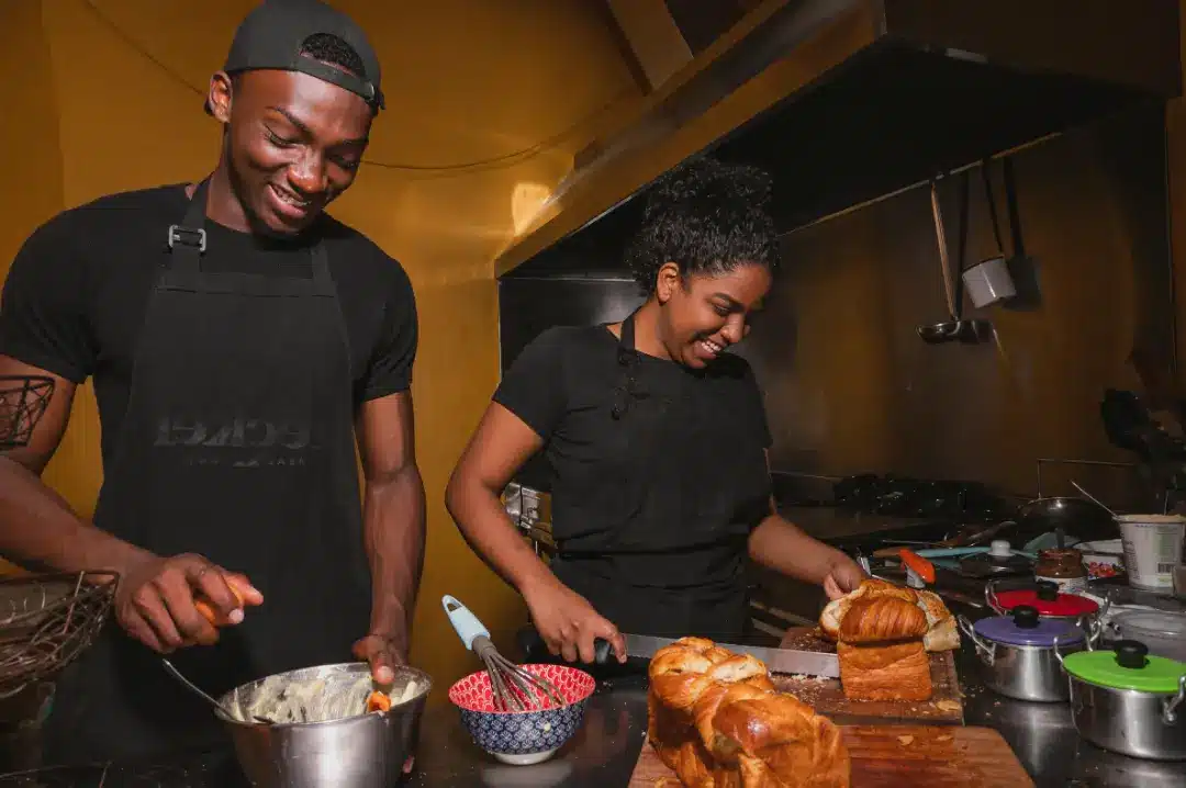 A man and a woman cooking food in a restaurant kitchen